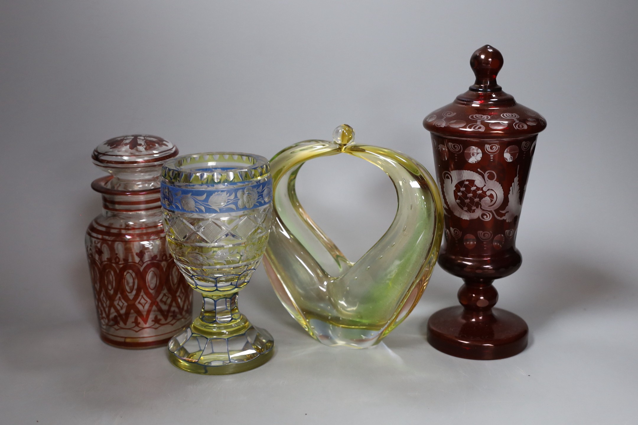 A Bohemian yellow and blue glass goblet, red overlaid vase and cover, another glass jar and cover and a Murano basket, tallest 24cm